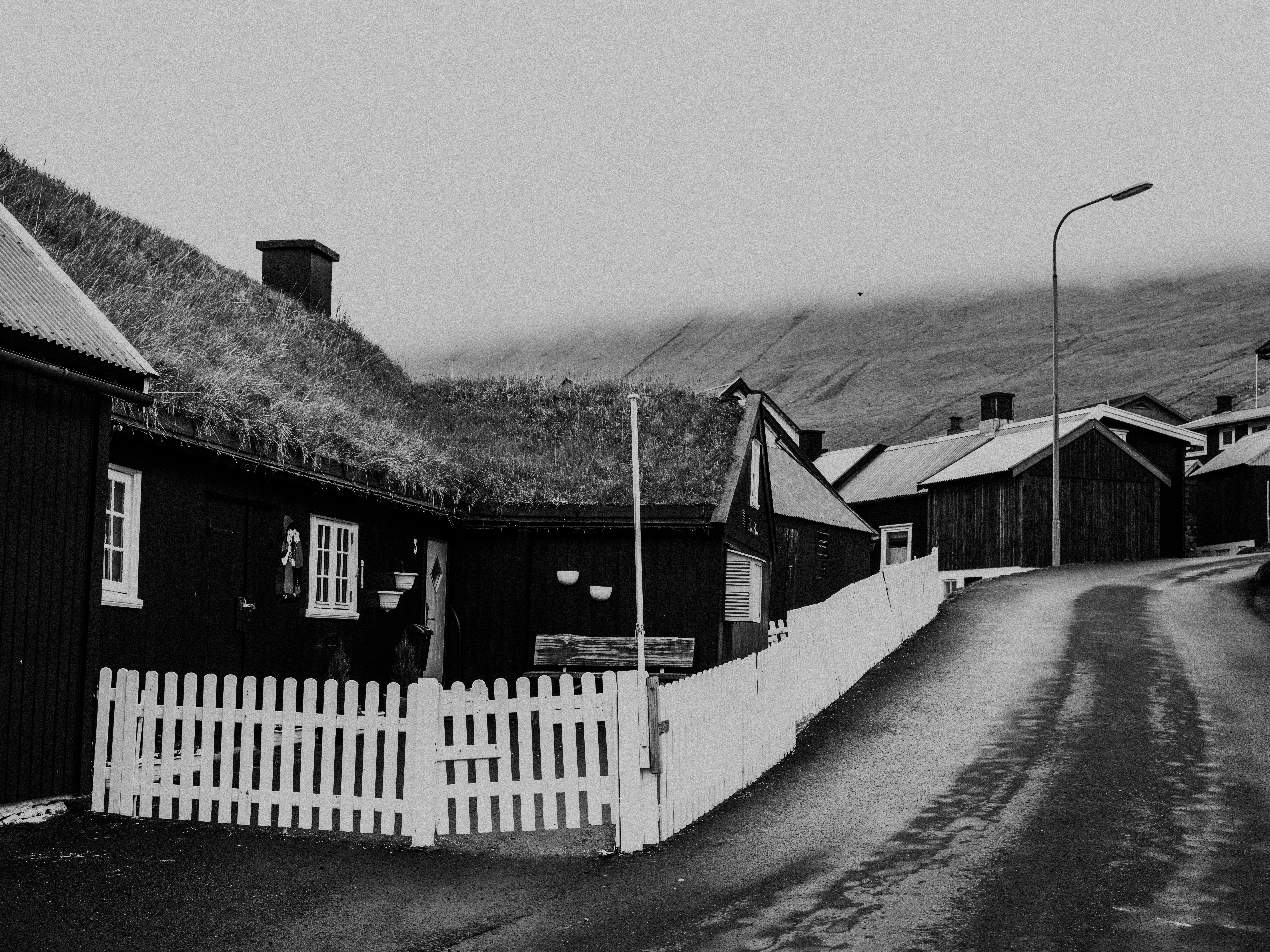 grayscale photo of houses beside road